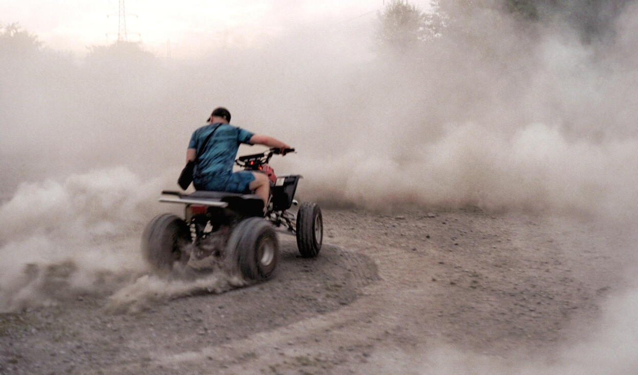 Rider kicking up dust on a quad bike Rider kicking up dust on a quad bike