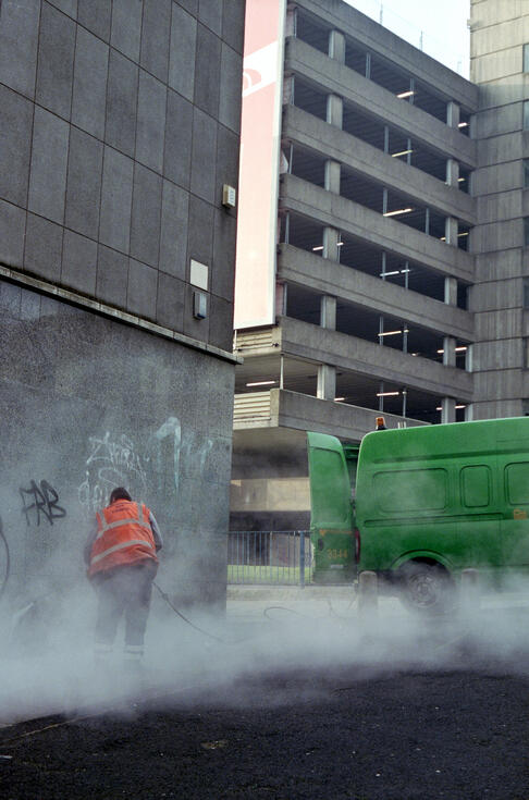 Street worker at first light amid rising mist Street worker at first light amid rising mist
