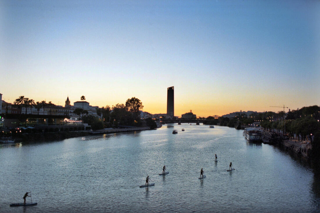 Paddleboarders on the Guadalquivir at sunset, Seville Paddleboarders on the Guadalquivir at sunset, Seville