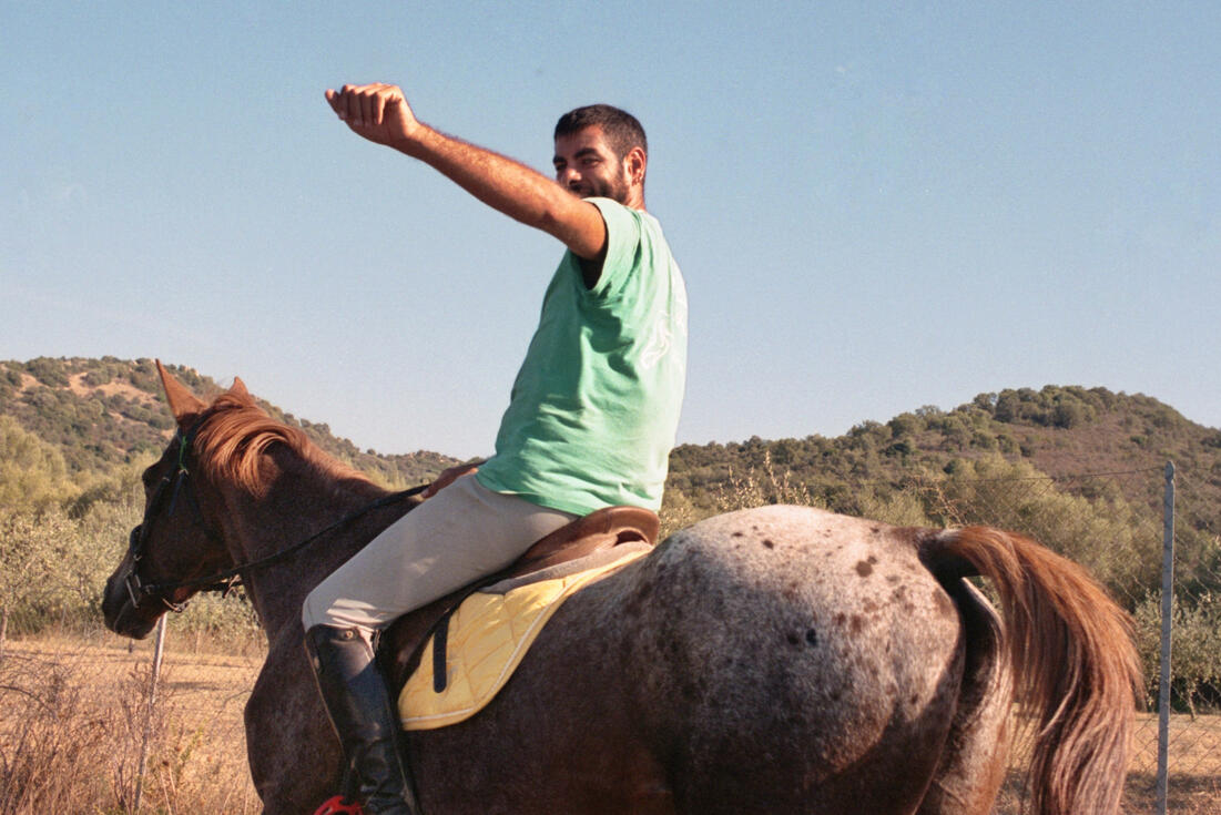 Horse rider raising his arm in the Sardinian hills Horse rider raising his arm in the Sardinian hills