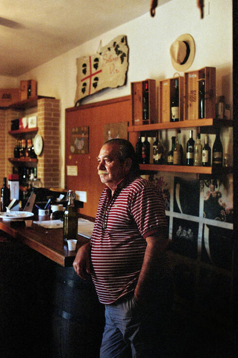 Cantina owner behind his bar of Sardinian wines Cantina owner behind his bar of Sardinian wines