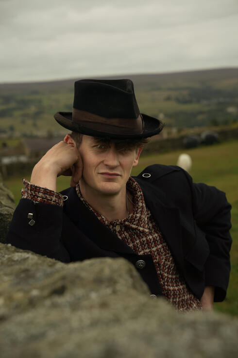 Member of The Homburgs in hat and coat on a hillside Member of The Homburgs in hat and coat on a hillside