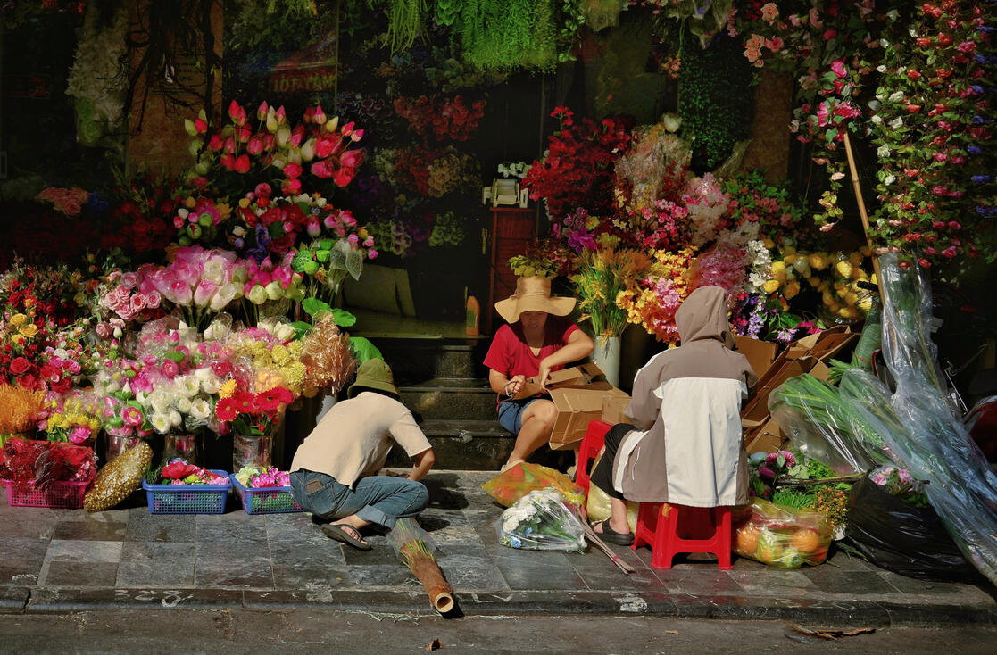 Flower sellers surrounded by roses at a Hanoi night market Flower sellers surrounded by roses at a Hanoi night market