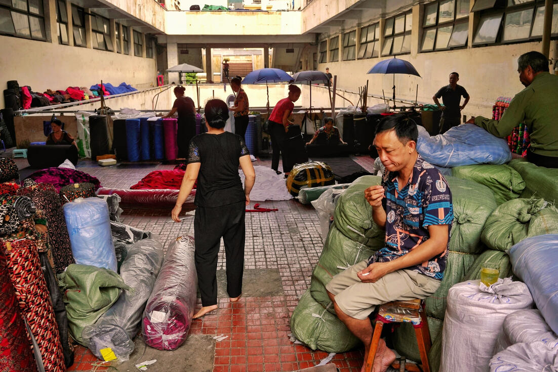 Trader resting among fabric rolls at a Hanoi wholesale market Trader resting among fabric rolls at a Hanoi wholesale market