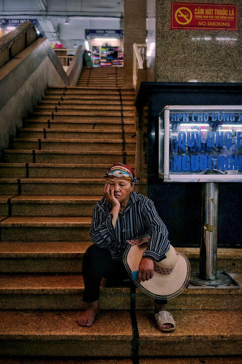 Tired market trader resting on steps at Dong Xuan market, Hanoi Tired market trader resting on steps at Dong Xuan market, Hanoi